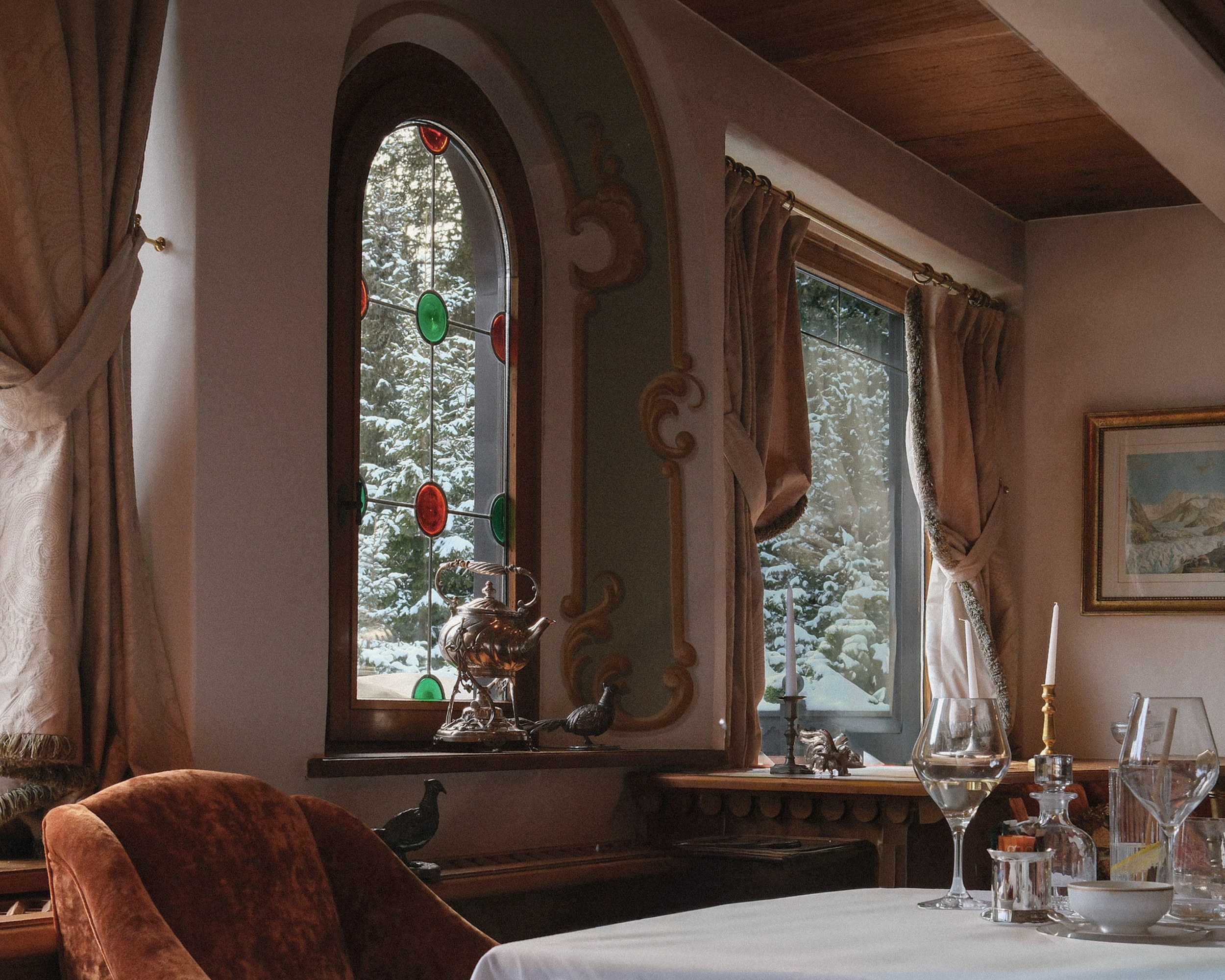 The dining room at the corner window, the samovar catching the afternoon light, a table laid with glasses and candles