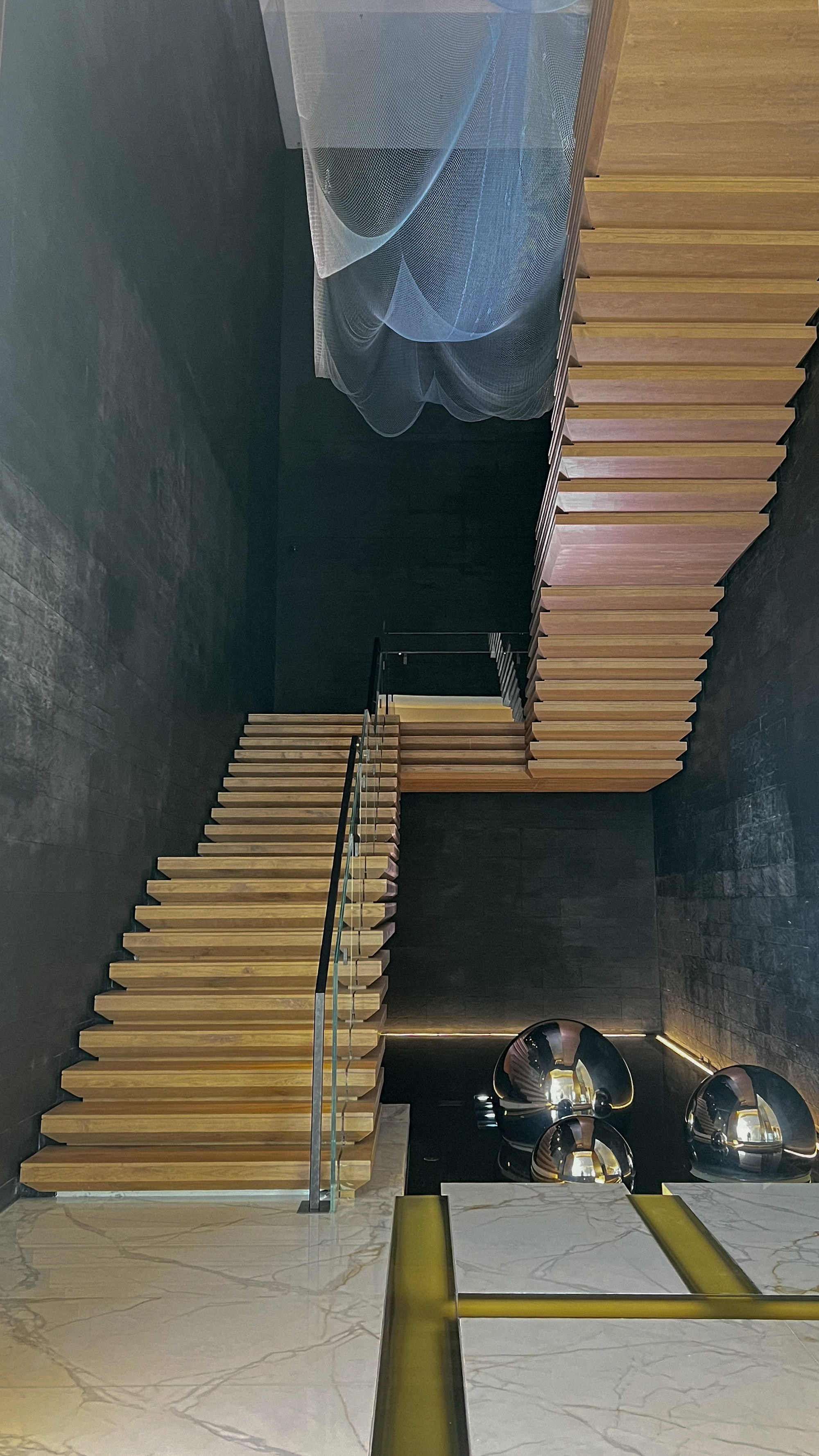 The floating stair turning through the dark shaft
