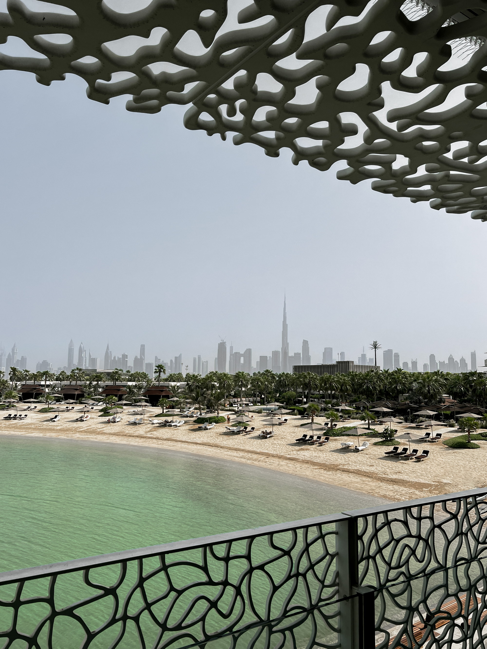The lagoon and beach beneath the coral canopy, the city beyond