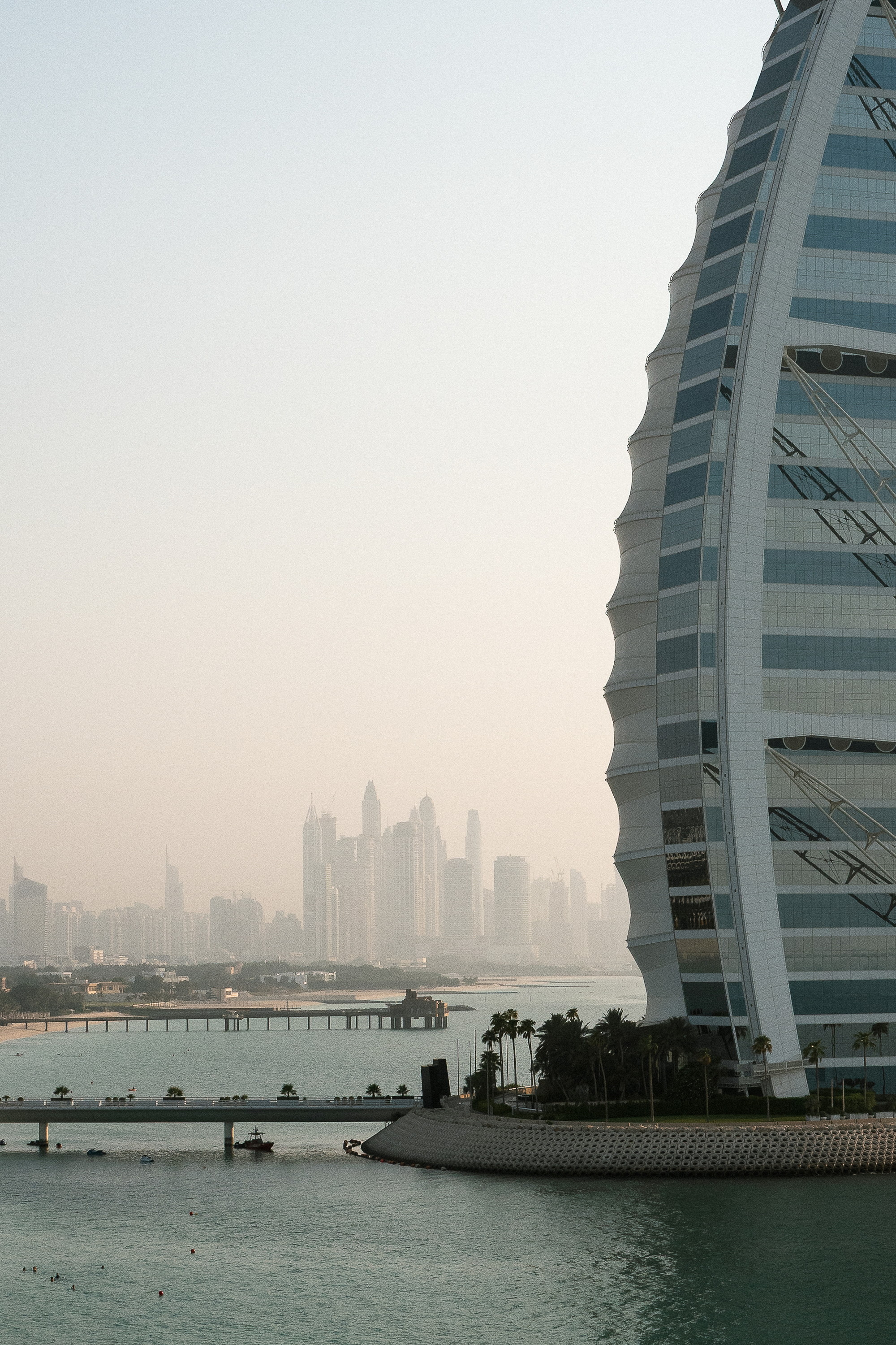 The sail from across the water, the Marina skyline standing in dust haze