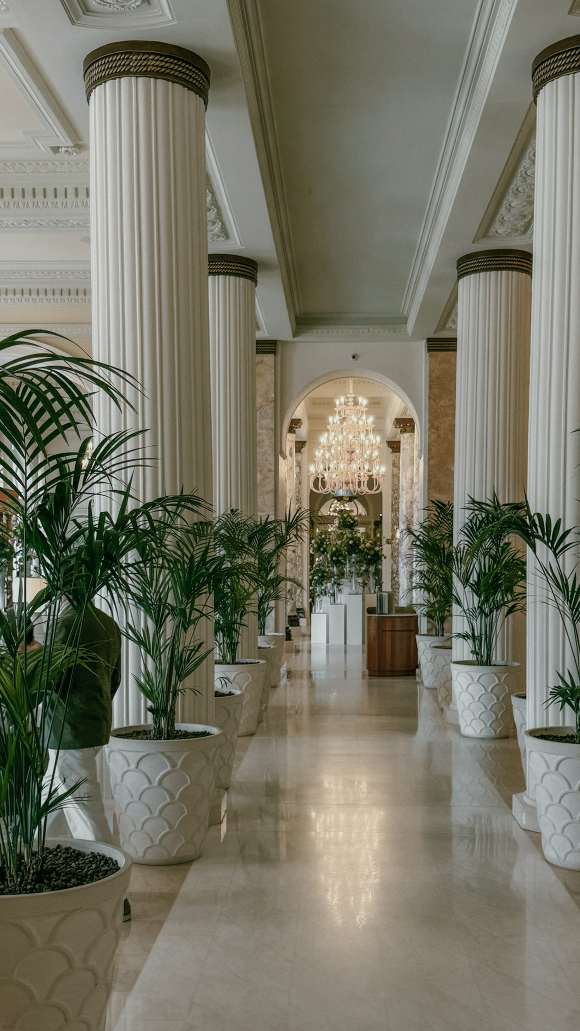 The colonnade, scallop planters marching to the chandelier