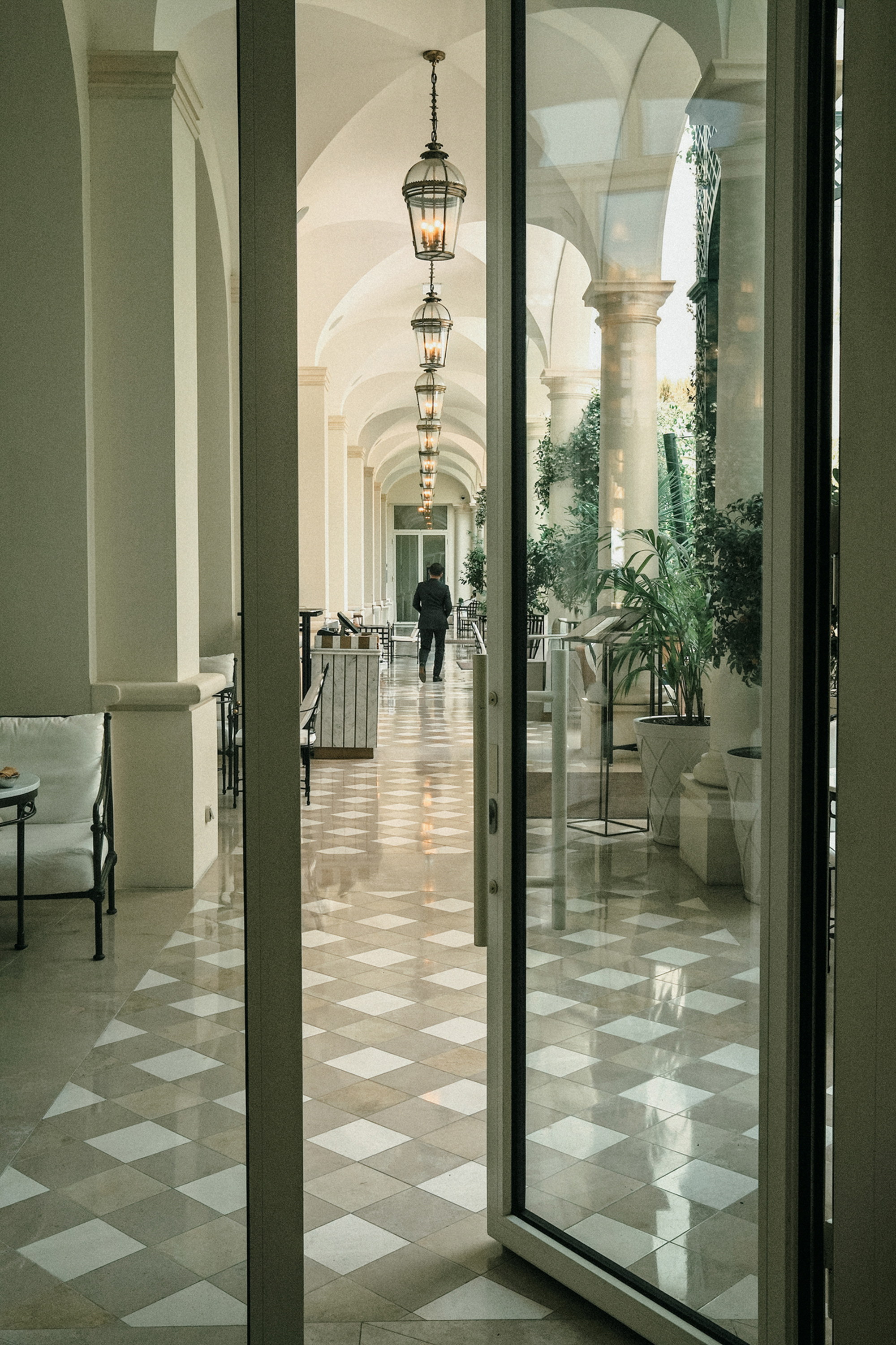 The gallery through the glass door, lanterns receding