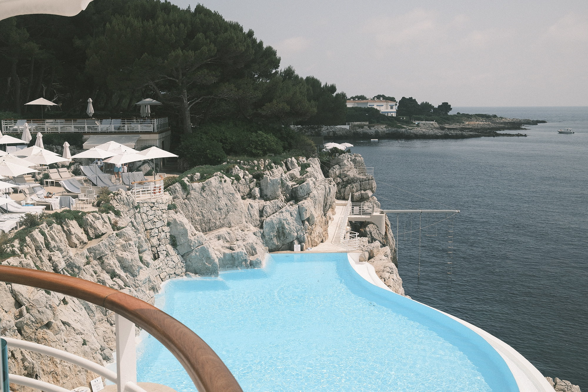 The pool cut into the rock, seen past the balcony rail