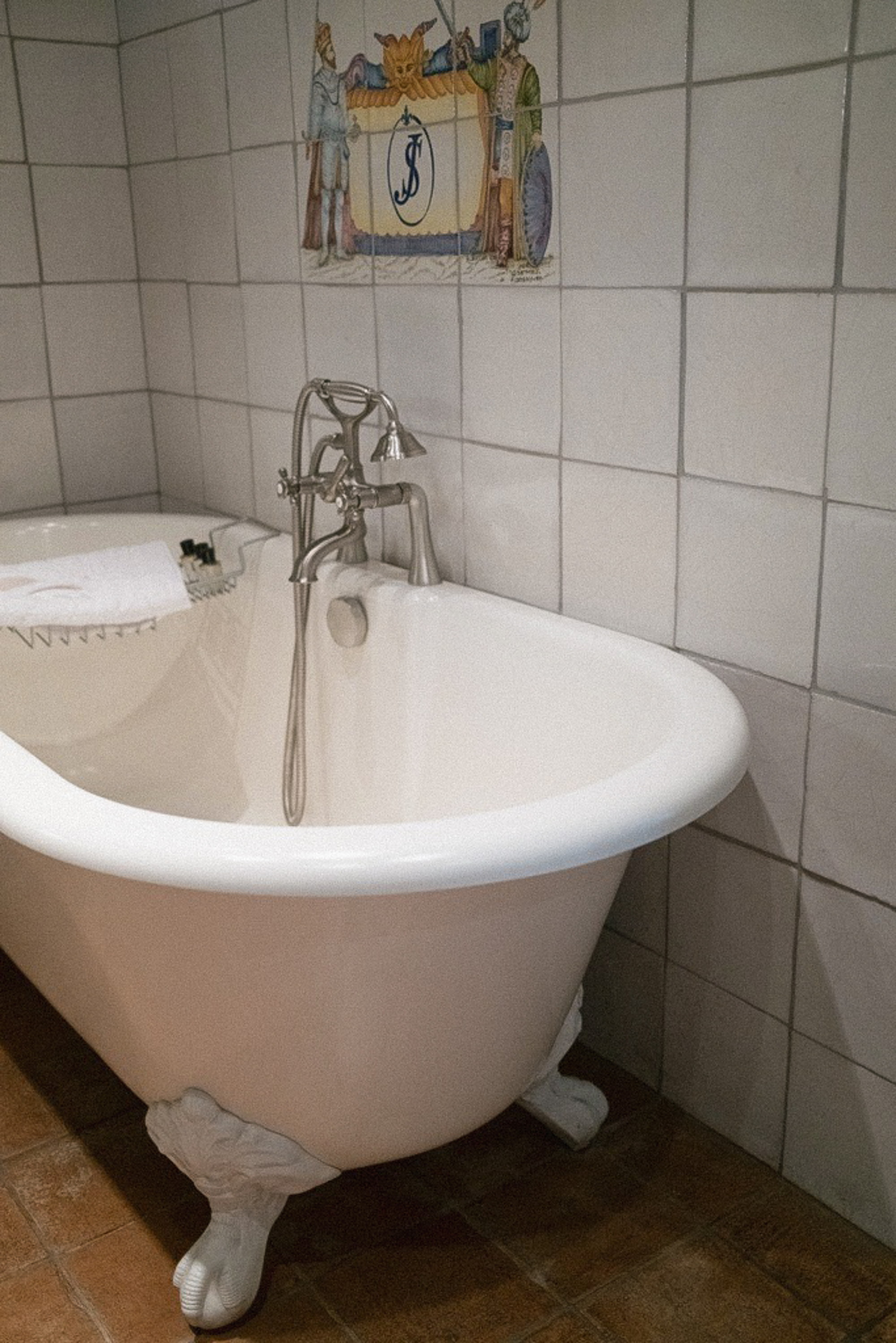 The clawfoot bath under the painted crest