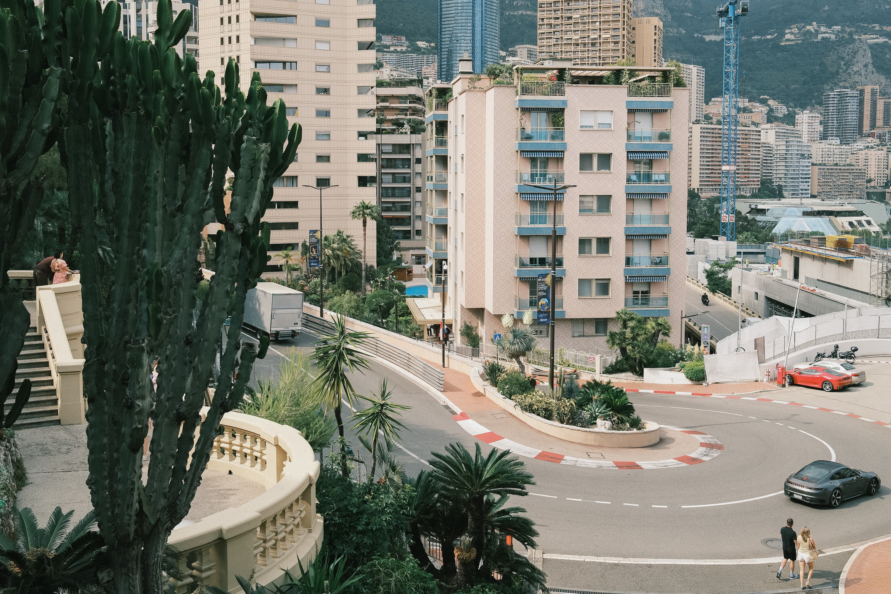 The hairpin from the terrace, a cactus in the foreground, the city climbing behind