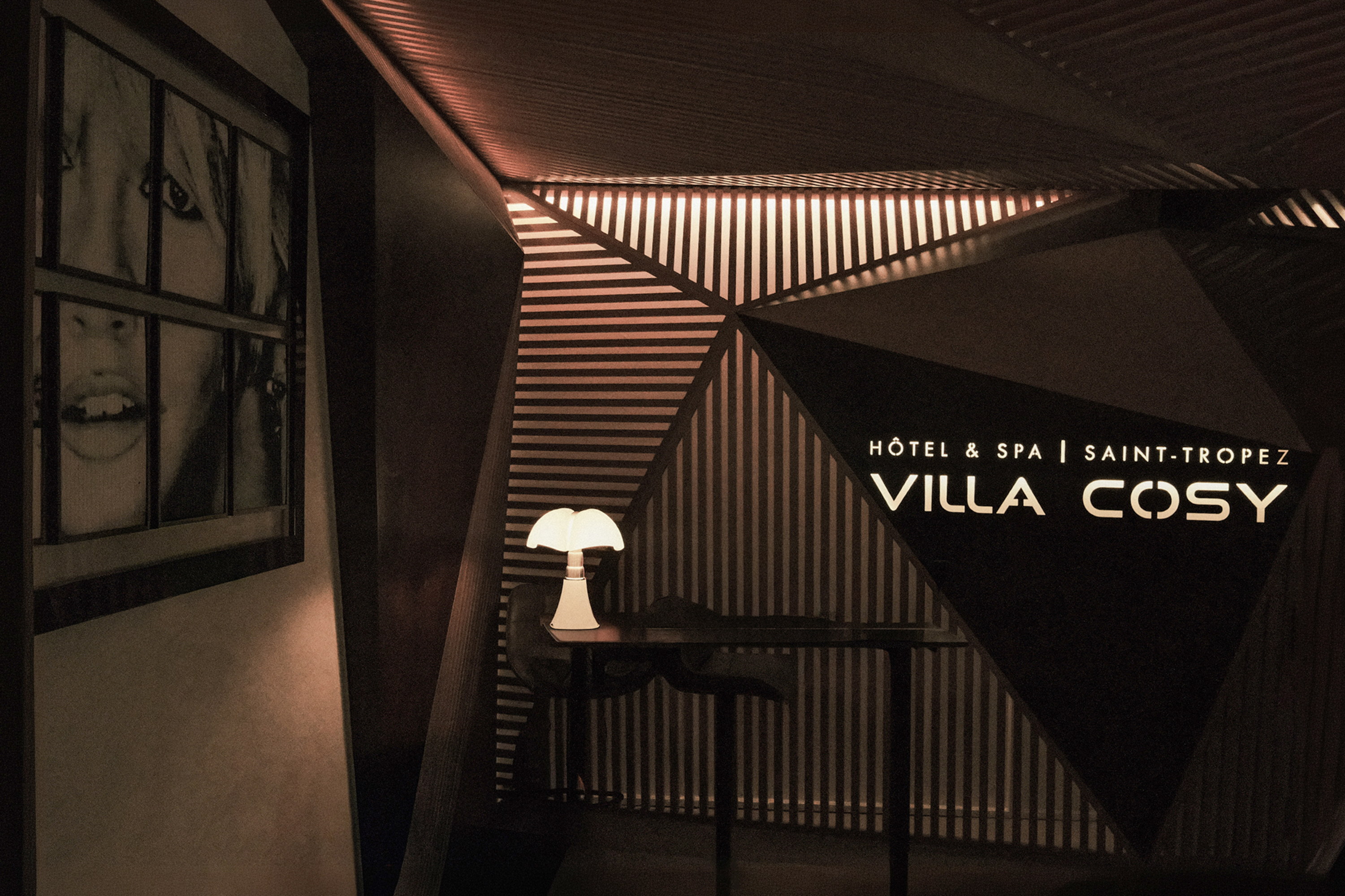Villa Cosy written in light, the lounge folding into dark