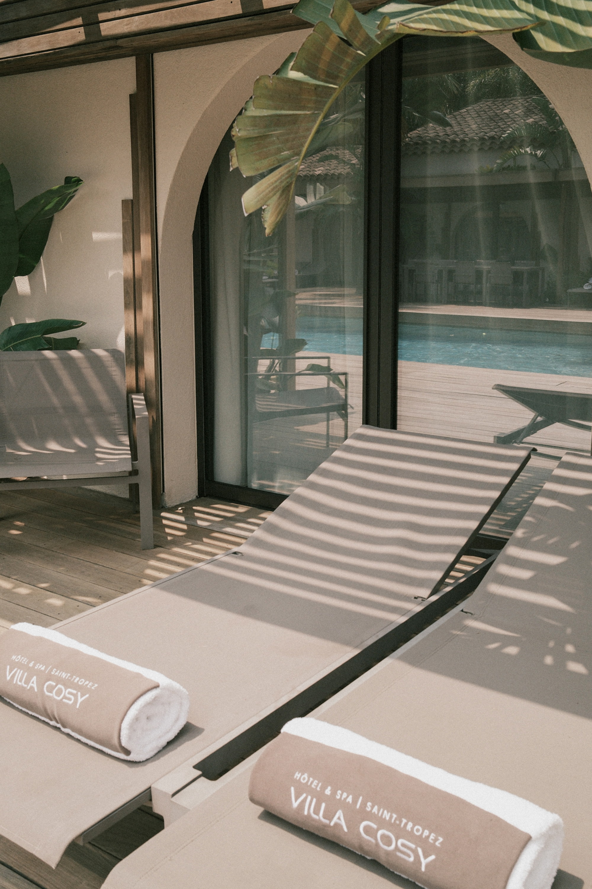 Chaises in striped light, the towels marked Villa Cosy